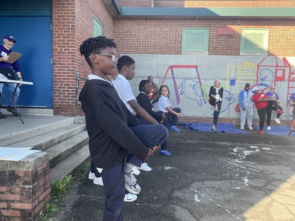 Students and staff stretch before the playground build at Sinclair Elementary.