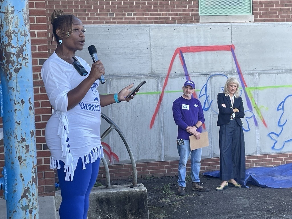 Principal Arrington leads stretching before a playground build at Sinclair Elementary. 