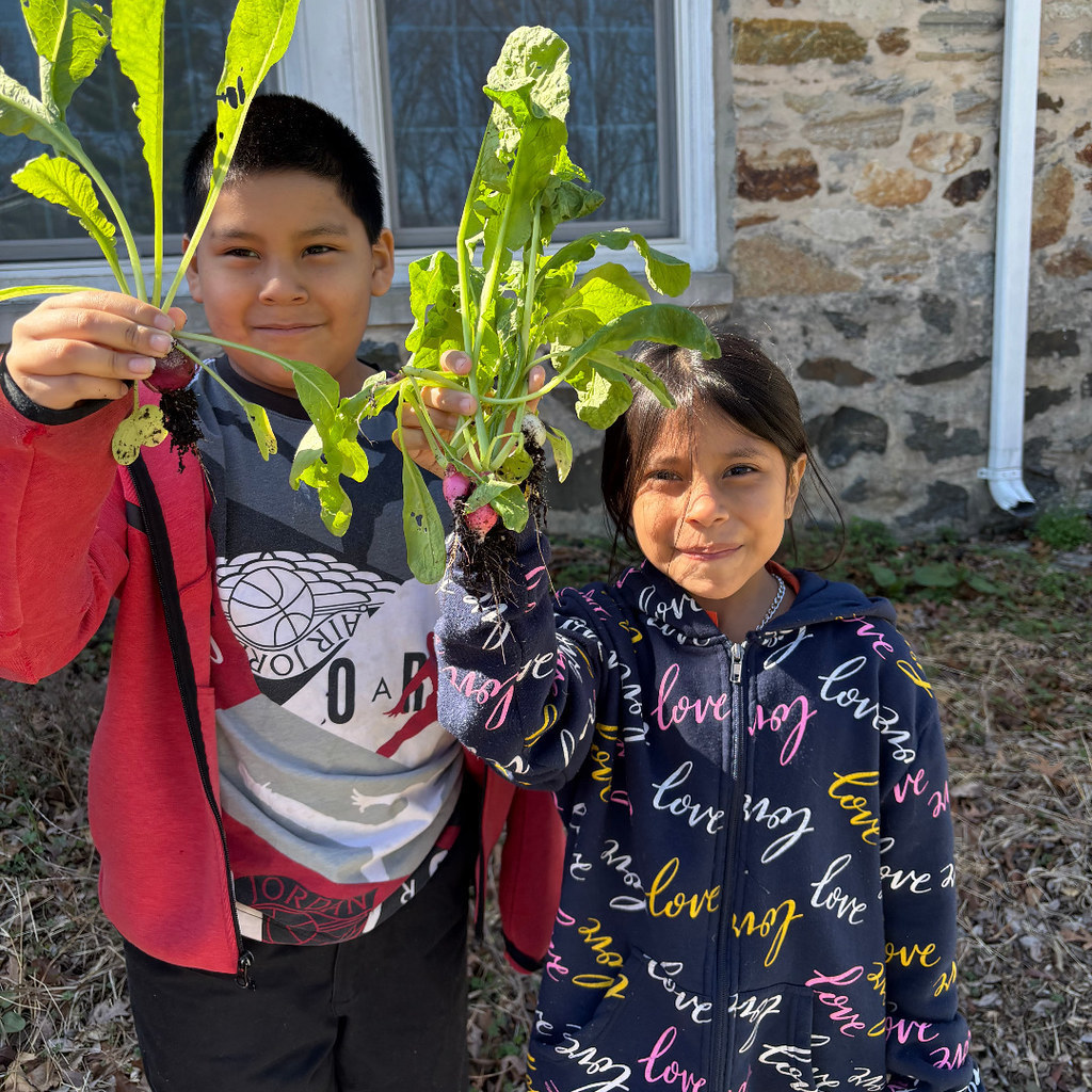 Two students holding plants at Great Kids Farm