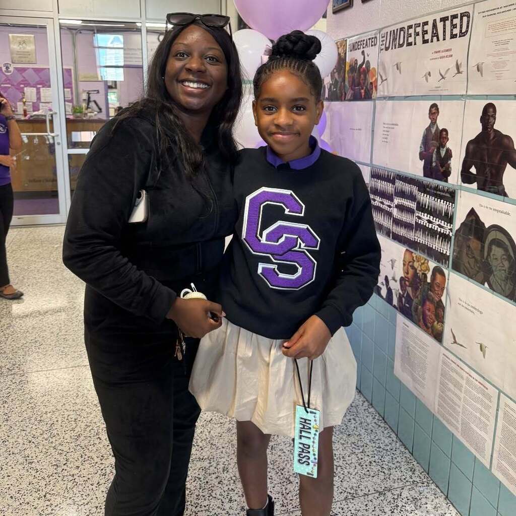 Student with an adult posing in the school hallway