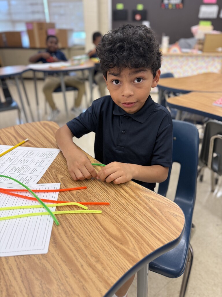 Student sitting at their desk building with pipe cleaners
