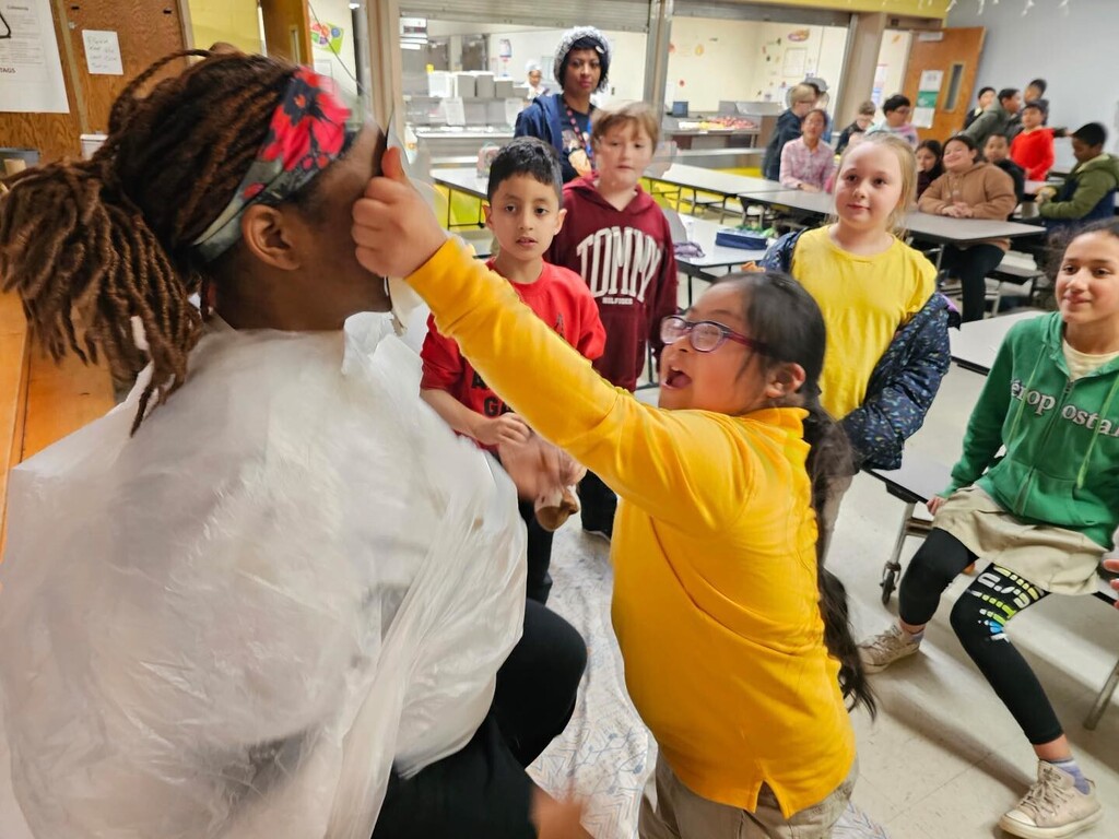 student smashing a pie in a teacher's face on Pi Day