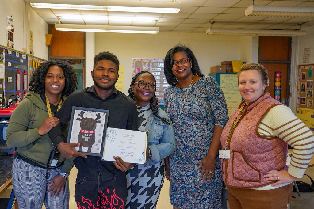 Tyrell poses with teachers and City Schools CEO at Joseph C. Briscoe Academy