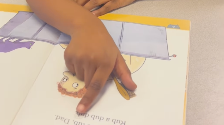 student reads with the help of their finger.