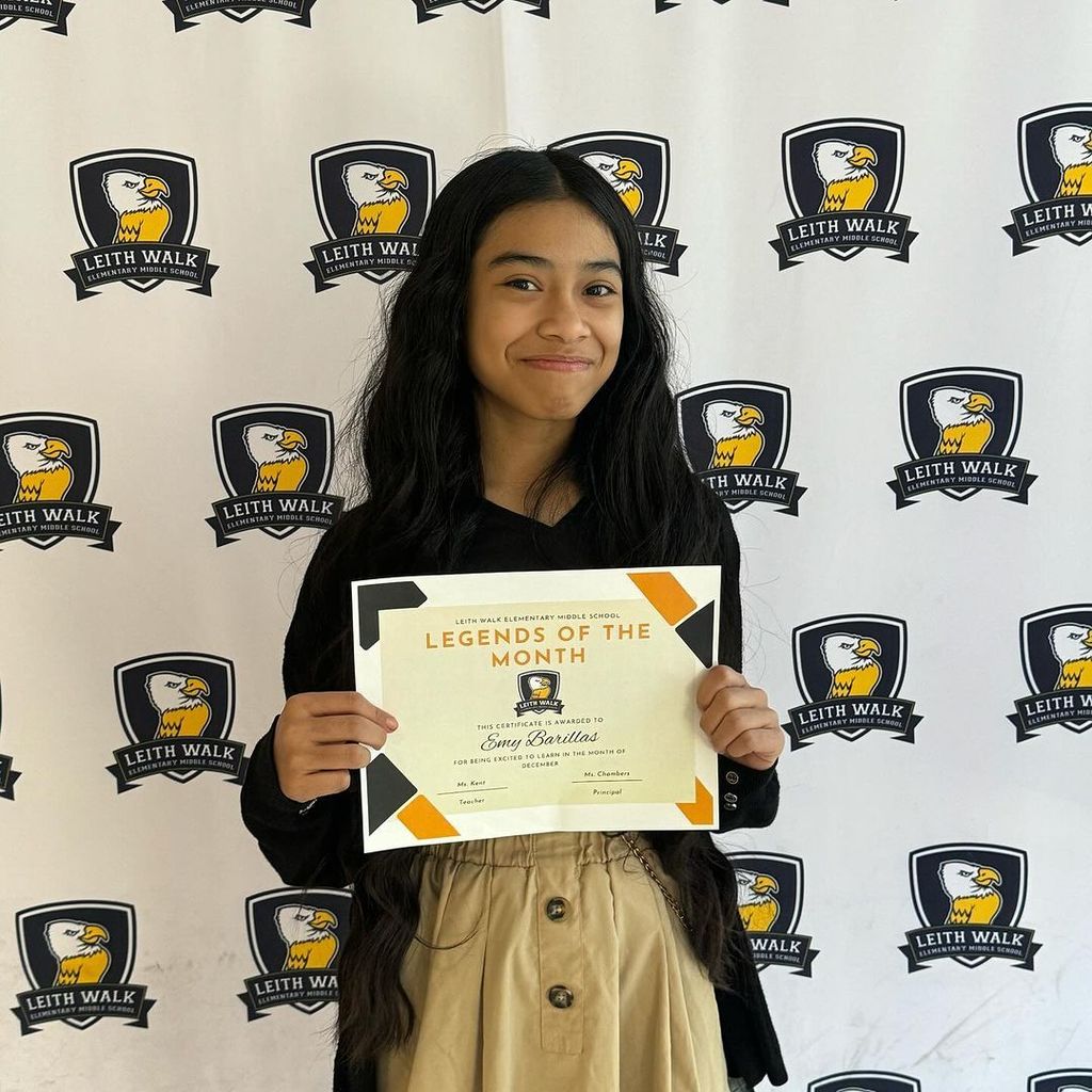 Student poses with her student of the month certificate.