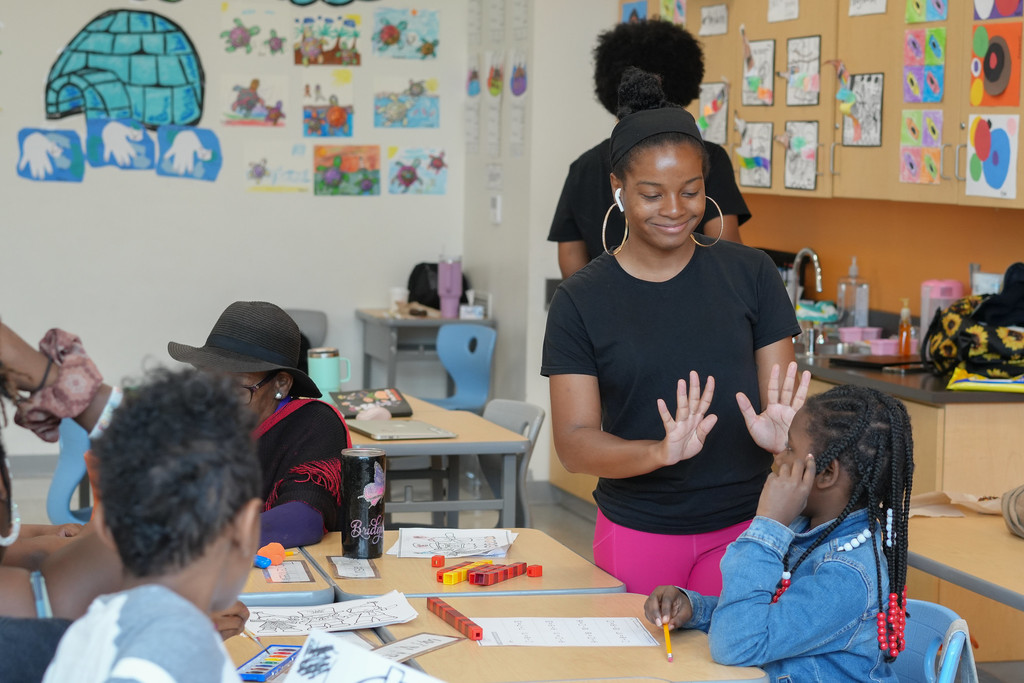 Teacher assists student with their artwork at Fort Worthington summer program.
