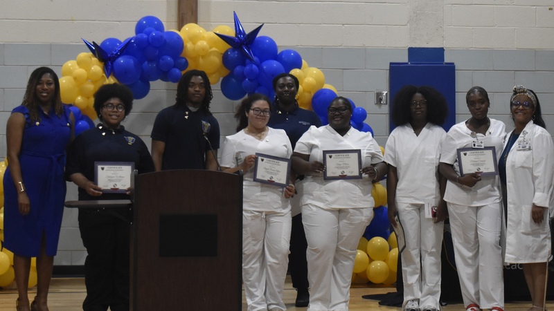 Principal Bush and students at pinning ceremony with students who completed classwork in CNA in white.&nbsp; All of the students in the picture are certified phlebotomist.
