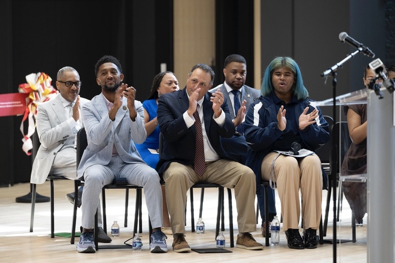 Baltimore City officials clap to celebrate the unveiling of the new Frederick Douglass building. 
