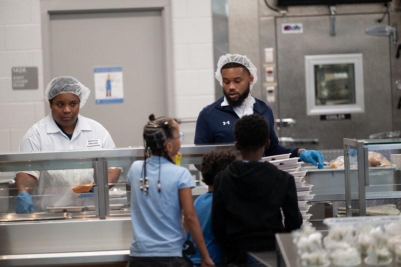 Food service staff serves students meals during lunchtime.