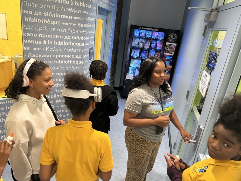 Ms. Cole and her students prepare to have a CHARM meeting in the KIPP library. 