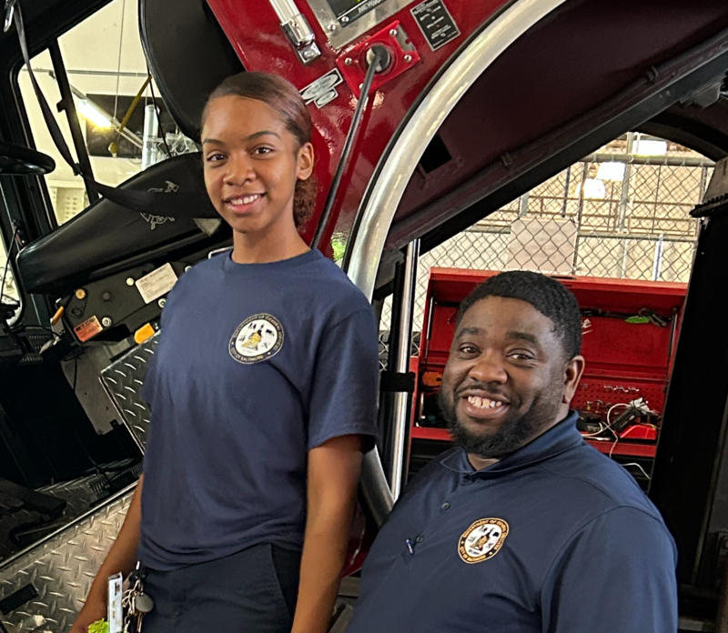 Celina, pictured left and Antwan pictured right, stand by a fire truck they are fixing. 