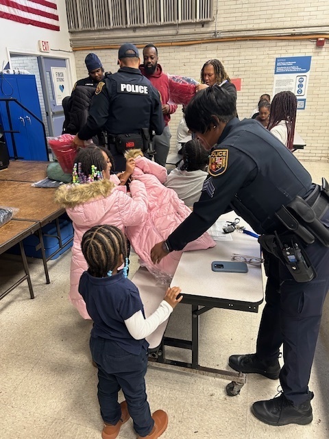 School Police hand out coats and pose for photos at Midtown Academy 