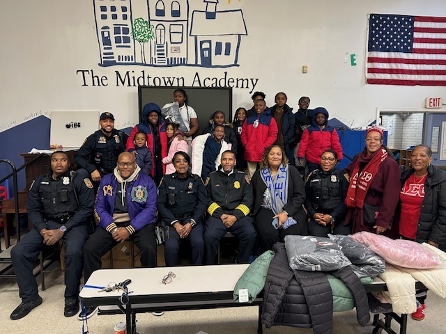 School Police hand out coats and pose for photos at Midtown Academy 