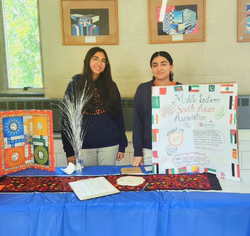 Two students at board promoting club