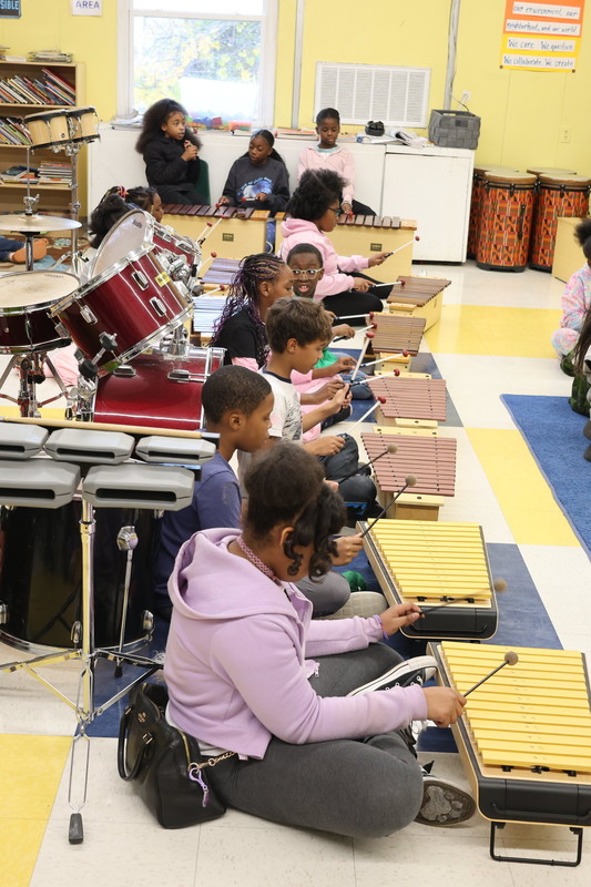 Creative City students play the xylophone during music class.