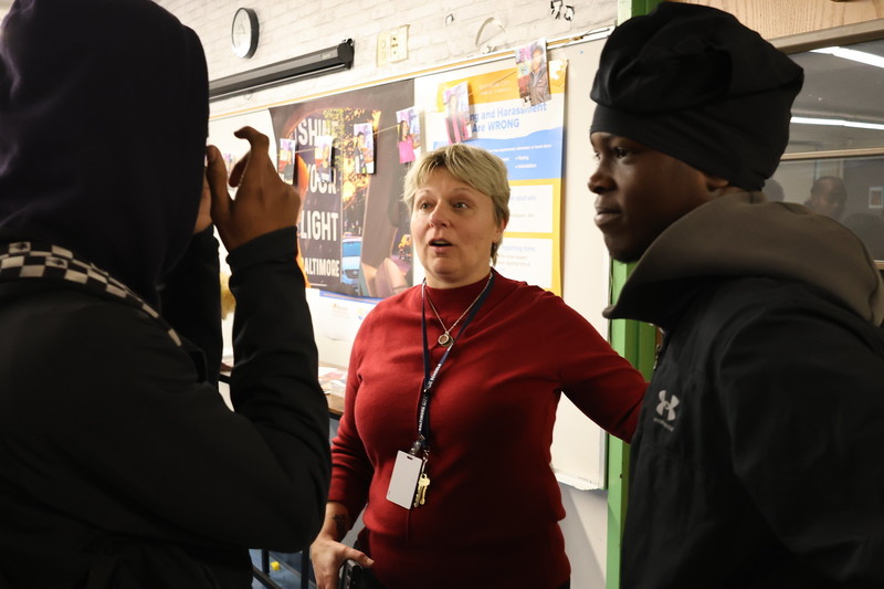 Teacher speaking with two students