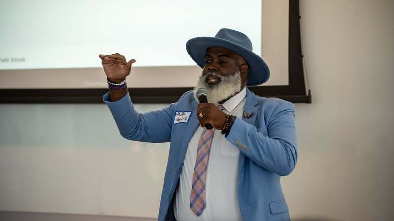 MWBE symposium presenter stands in the front of the room speaking.