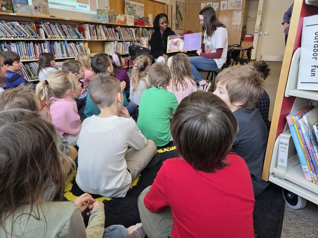Members of the BHS Library Book Club visited two first-grade classes at Fourteenth Street, guided by Librarian Ms. Sprague. The purpose of the visit was to read aloud to the children and carry out a craft activity. They shared the book Dewey: There's a Cat in the Library by Vicki Myron and Brett Witter, which tells the heartfelt story of a real cat. As a kitten, Dewey was unfortunately dropped into a library's book return dropbox one night in Spencer, Iowa. The librarians decided to adopt him as the "library cat," allowing patrons to interact with him over the years. After the reading session, the first graders enjoyed coloring, cutting, and assembling their own library cats to take home and read to.