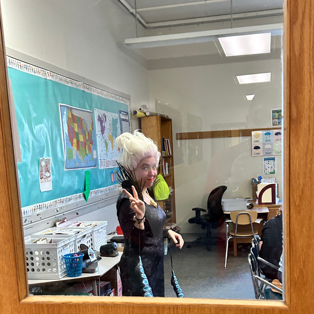 Ursula holding up a peace sign as she teaches French Class.