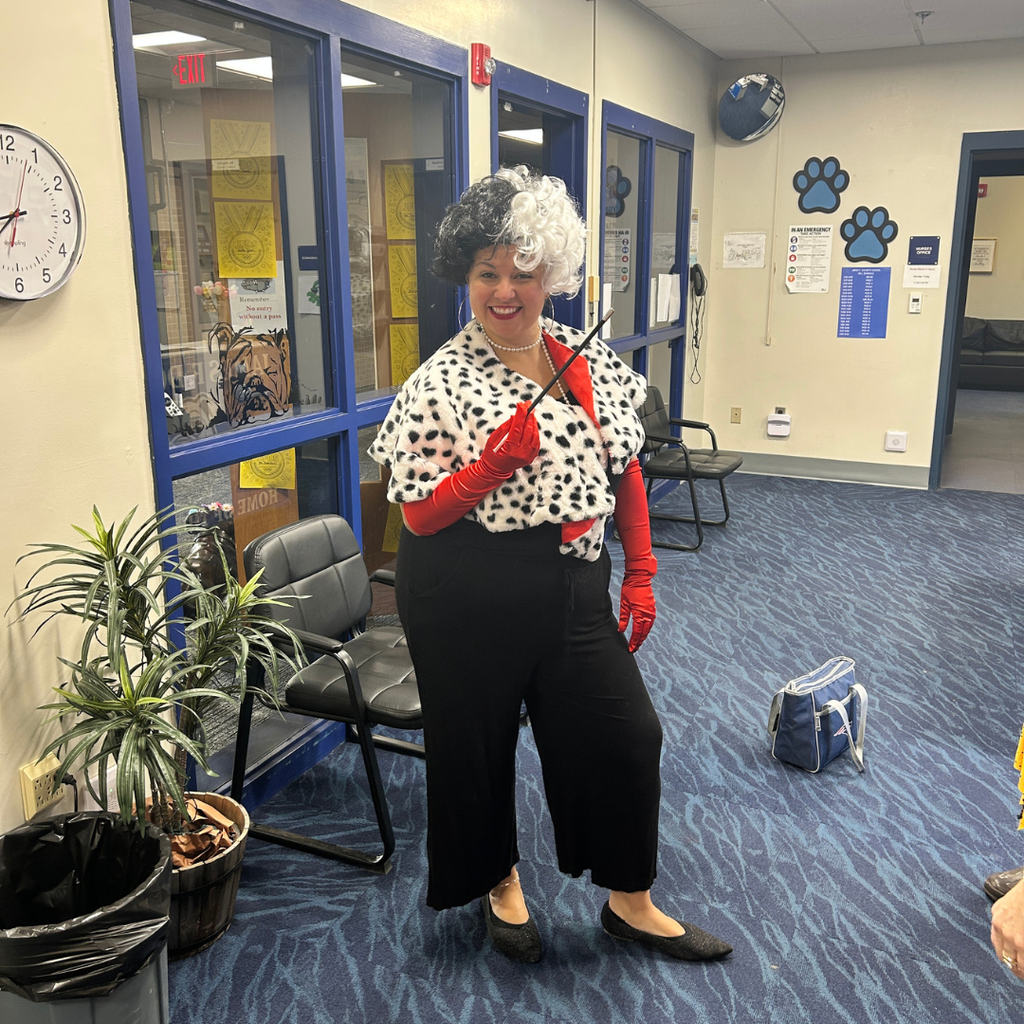 Staff dressed as Cruella DeVil showing off her costume
