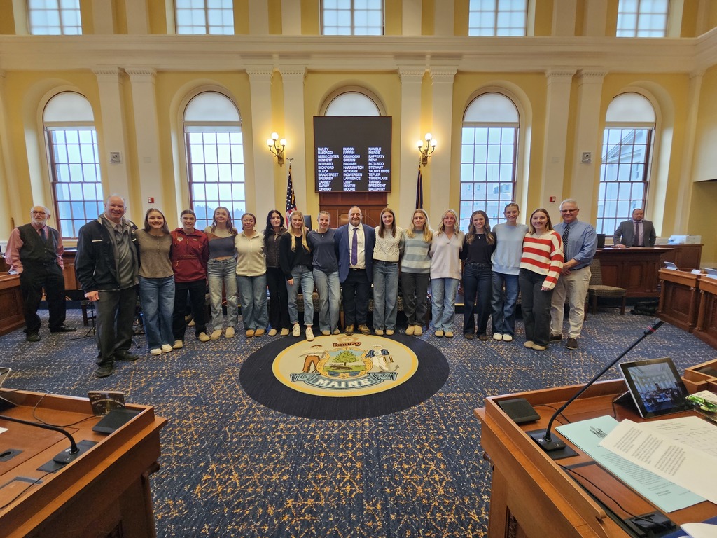 Members of the BHS girls  soccer team posing with Senator Baldacci in the Maine Senate Chambers.