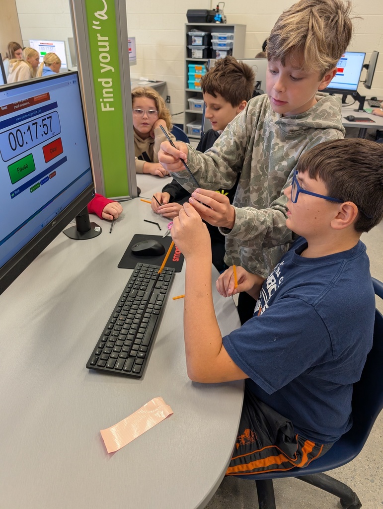 photo of two students building a straw structure