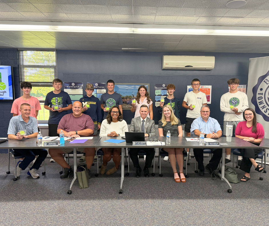 group of board members with tennis players presenting signed tennis balls