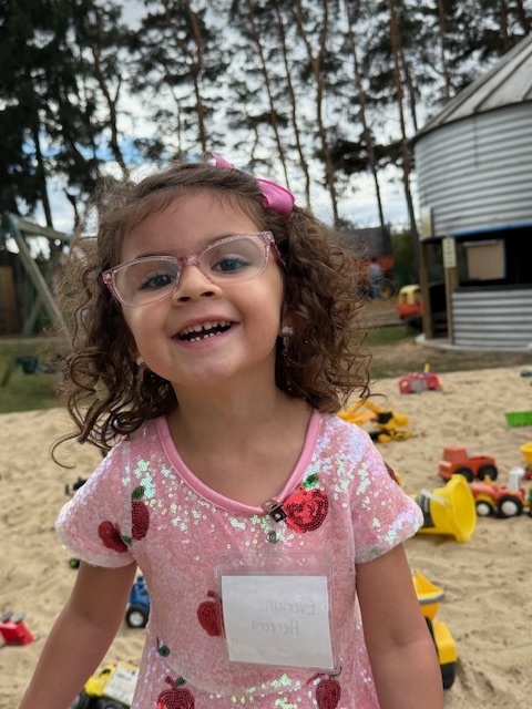 kid smiling in sandbox