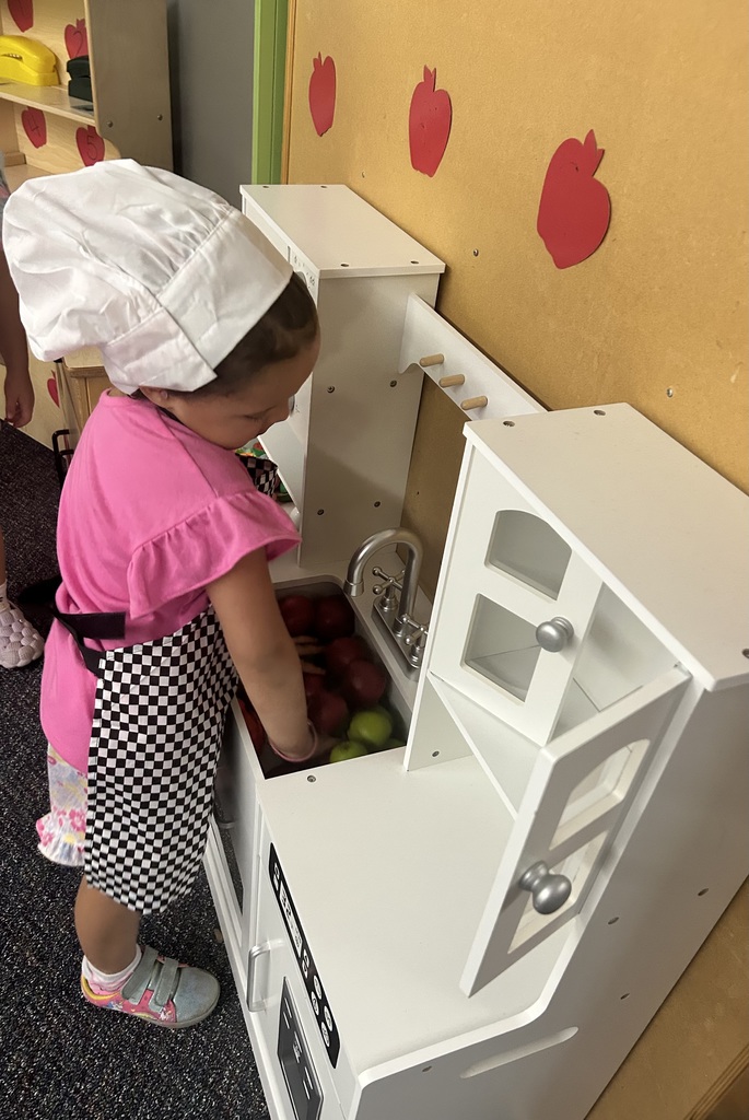 Student cooking play apples in housekeeping area