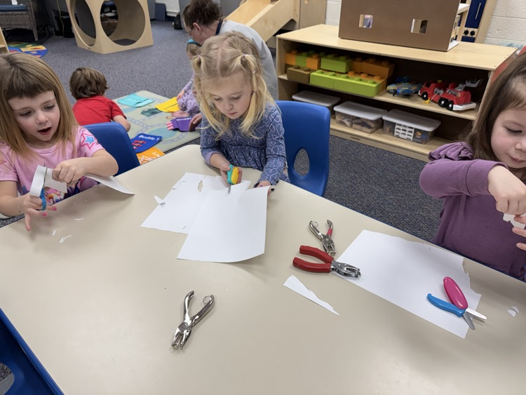 cutting out skirts for her dolls, so creative!