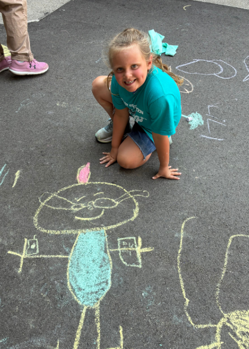 student drawing with chalk
