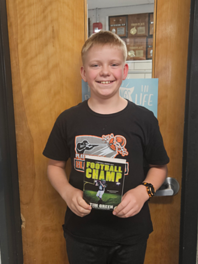 Student holding a prize for reading