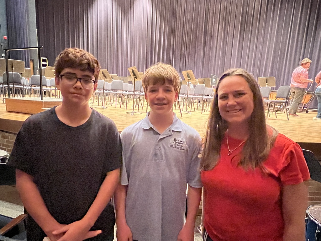 Two students standing with their teacher