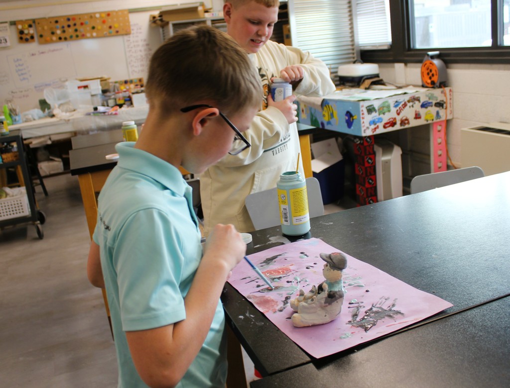 Students holding art projects