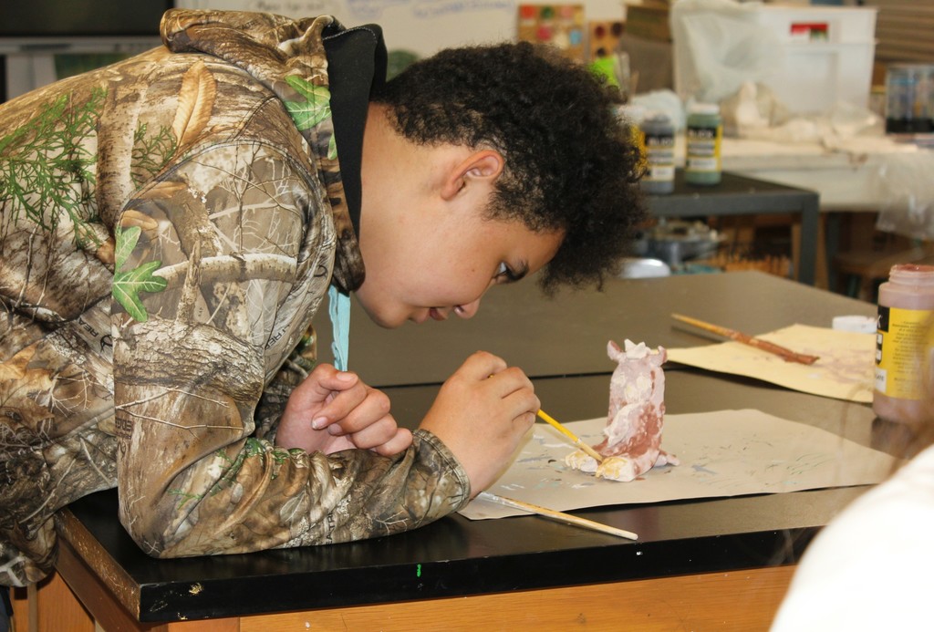 Students holding art projects
