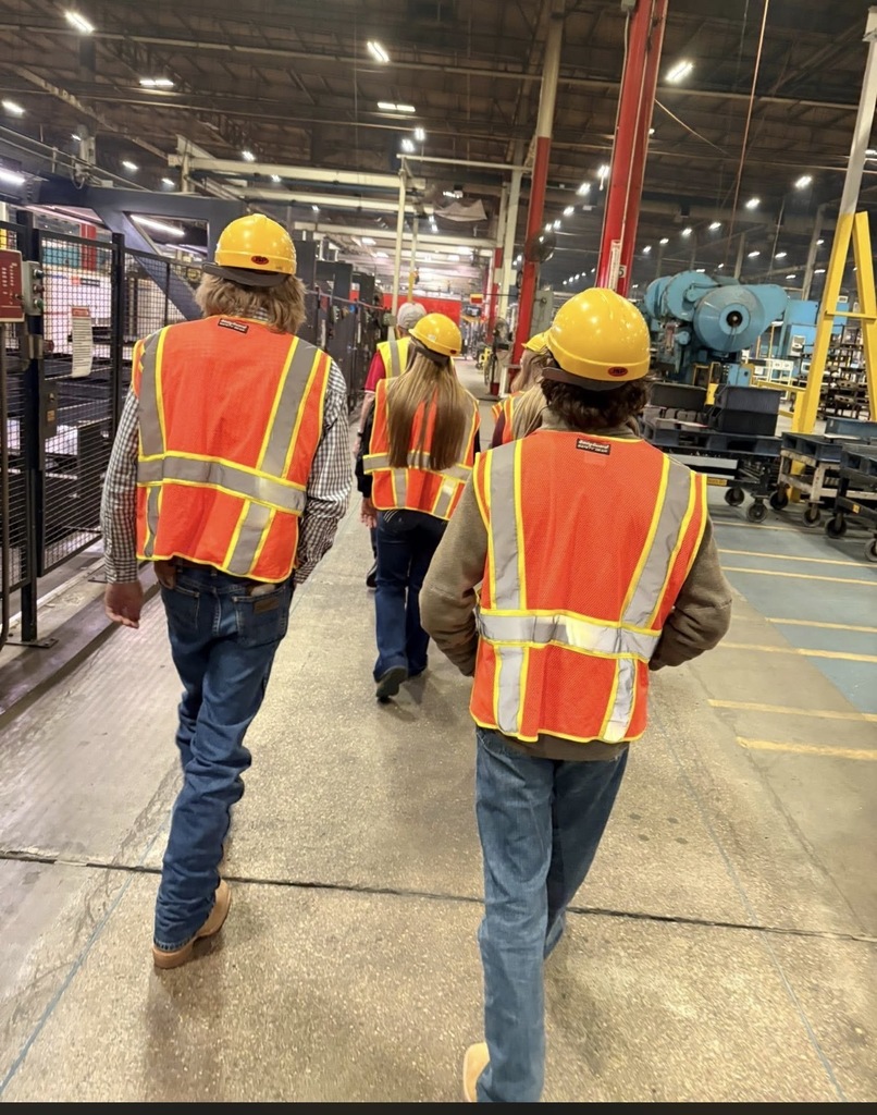 Students walking through a factory 