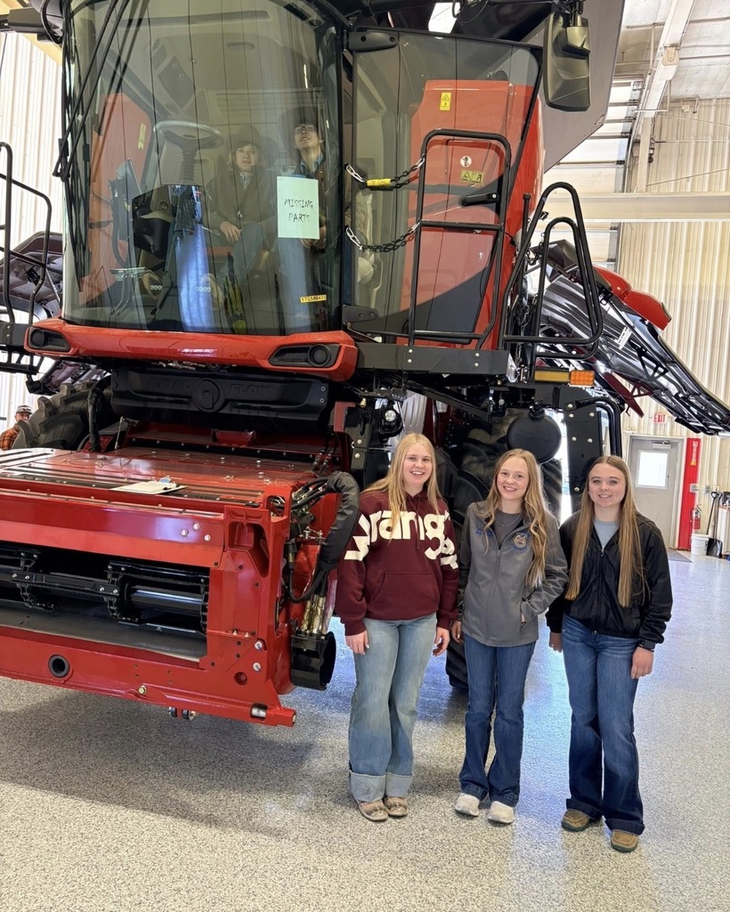Students standing in front of a combine