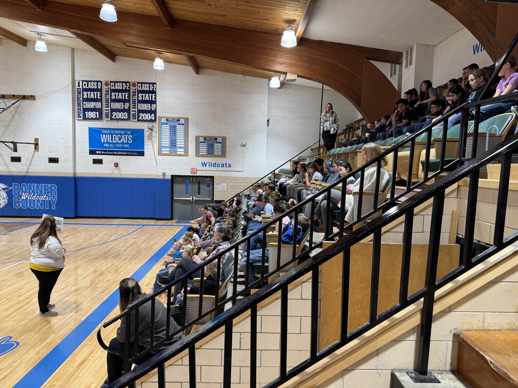 Students in the gym at an assembly 