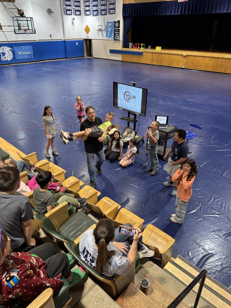 Students sitting in the bleachers listening to a speaker 