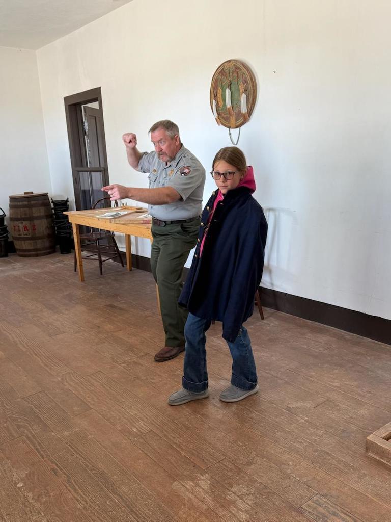 A series of photos showing Banner County students on a field trip to a historical museum or general store. Students are seen exploring vintage displays, looking at historical artifacts on wooden shelves, and gathered together in a rustic, wood-paneled building.