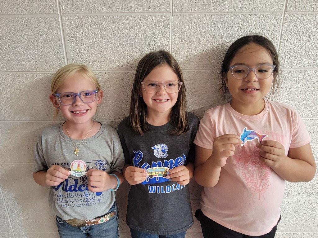 Three students holding prizes for reading