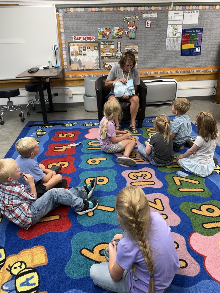 Adult reading to Kindergarteners 