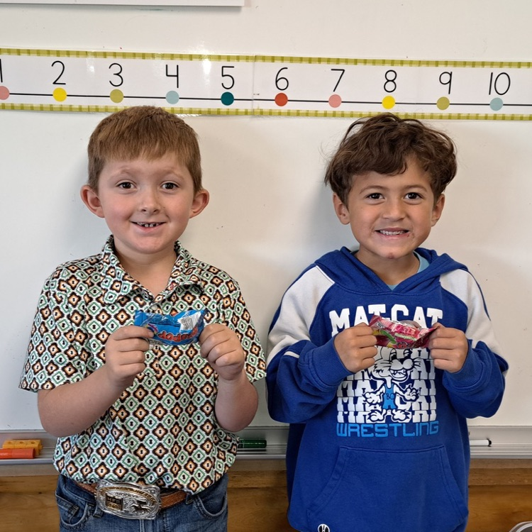 Two students holding candy