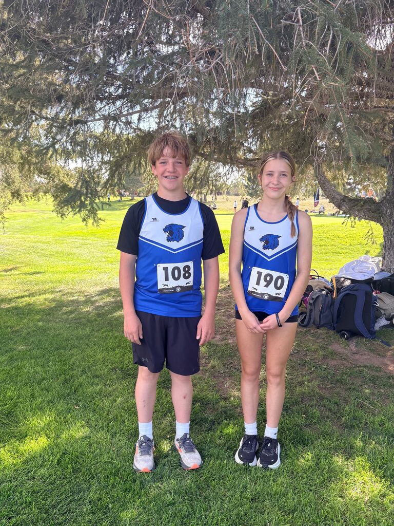 2 students standing by a tree