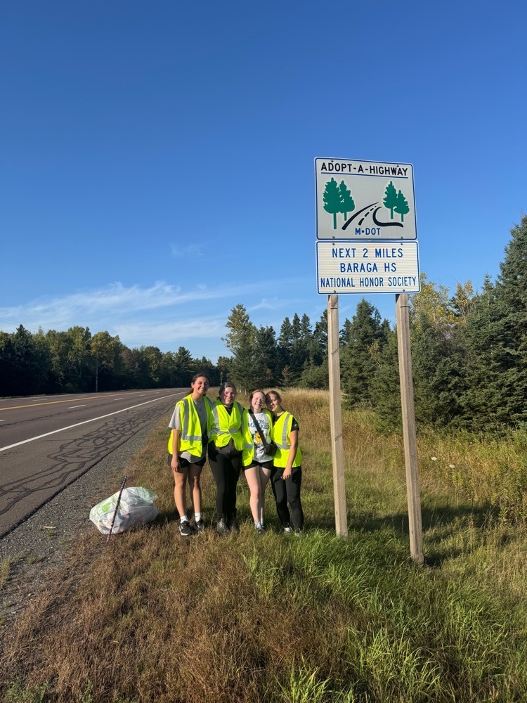 Students standing near the Adopt a Highway sign after cleaning the highway