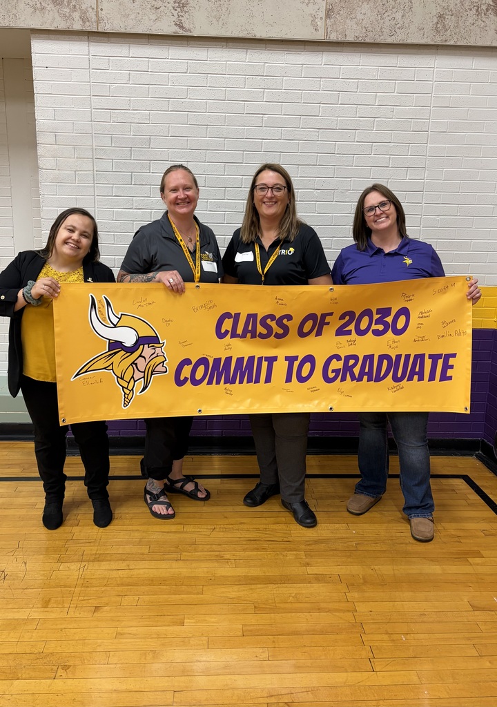 Picture of four people holding sign