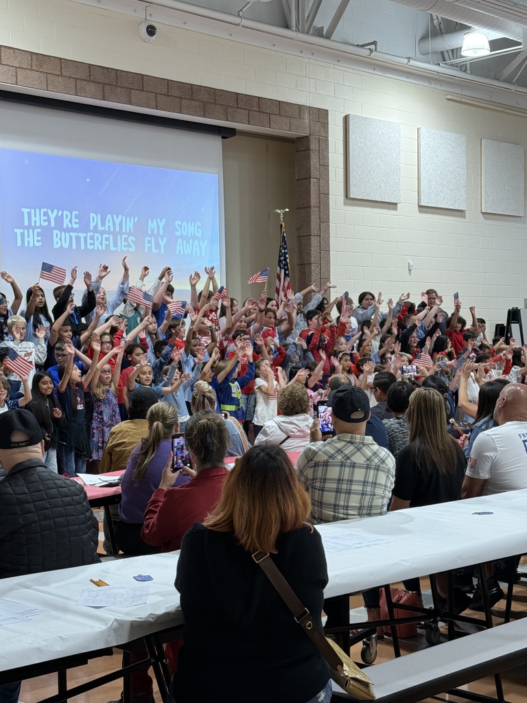 Students singing waving their hands during a song. 