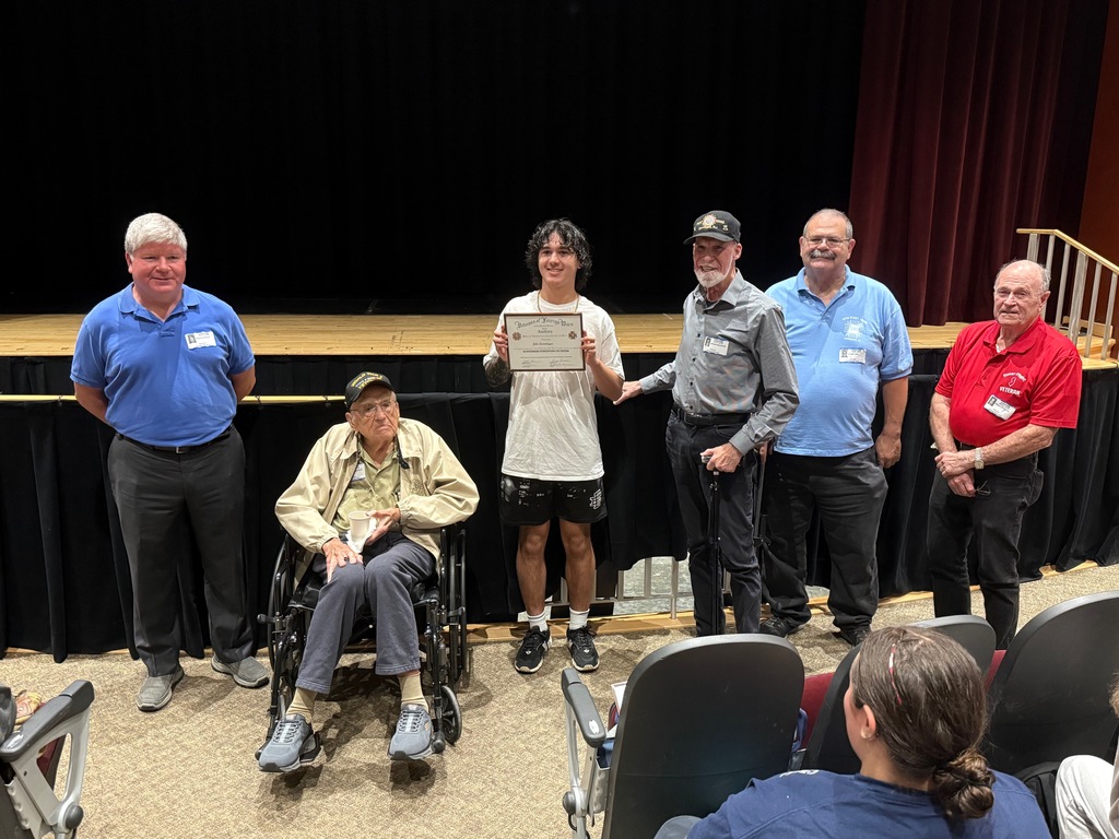 Five members of the VFW posing with Jake as he displays his award. 
