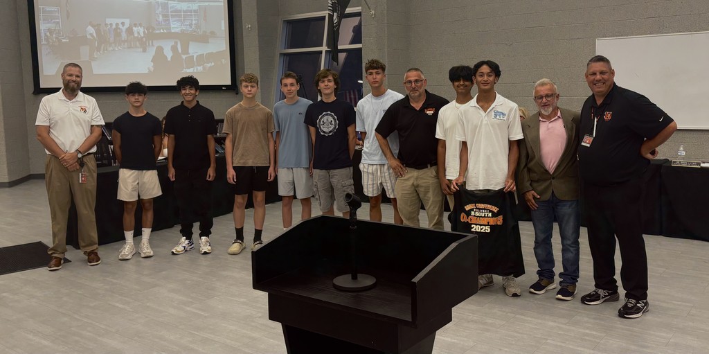 Boys volleyball team posing with the Superintendent, Athletic Director, BOE President, and their coach.
