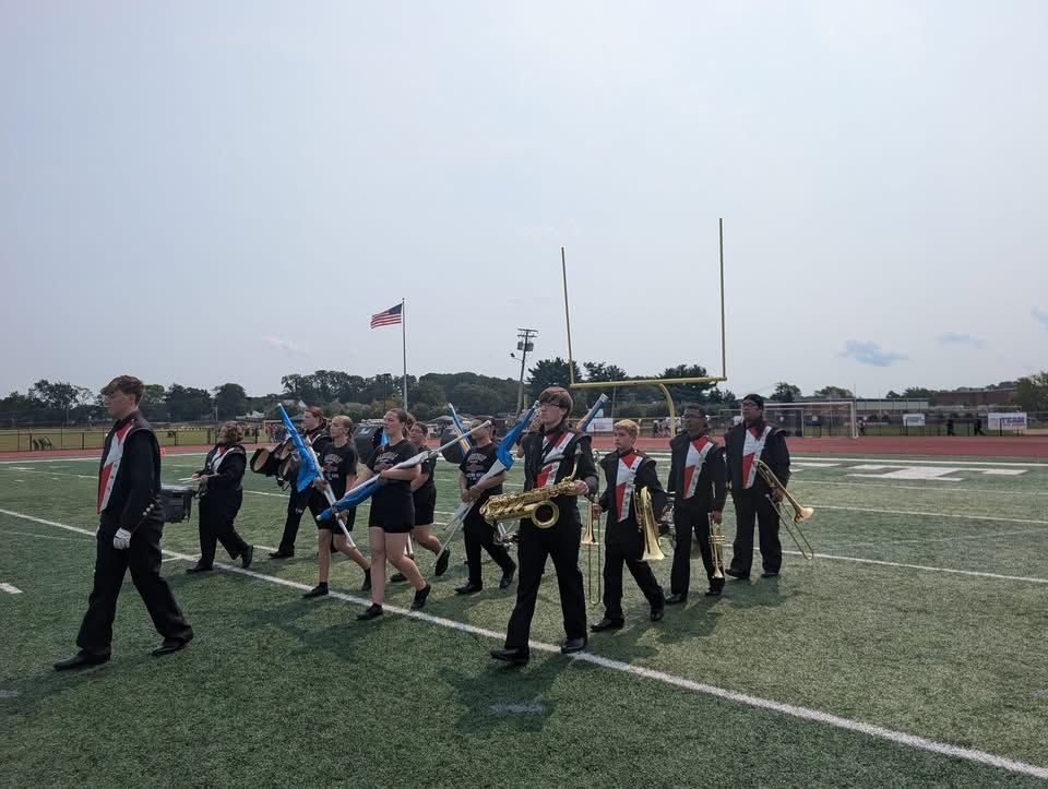 Image of the band walking on the field. 